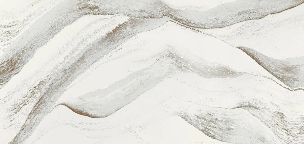 Chocolate brown streams converge along a cool white backdrop, their inviting translucence and momentous movement are punctuated by hints of brilliant brass. The alloy accent lightly traces the peaks and valleys of this flowing umber landscape for visual depth with a glint of glamour.