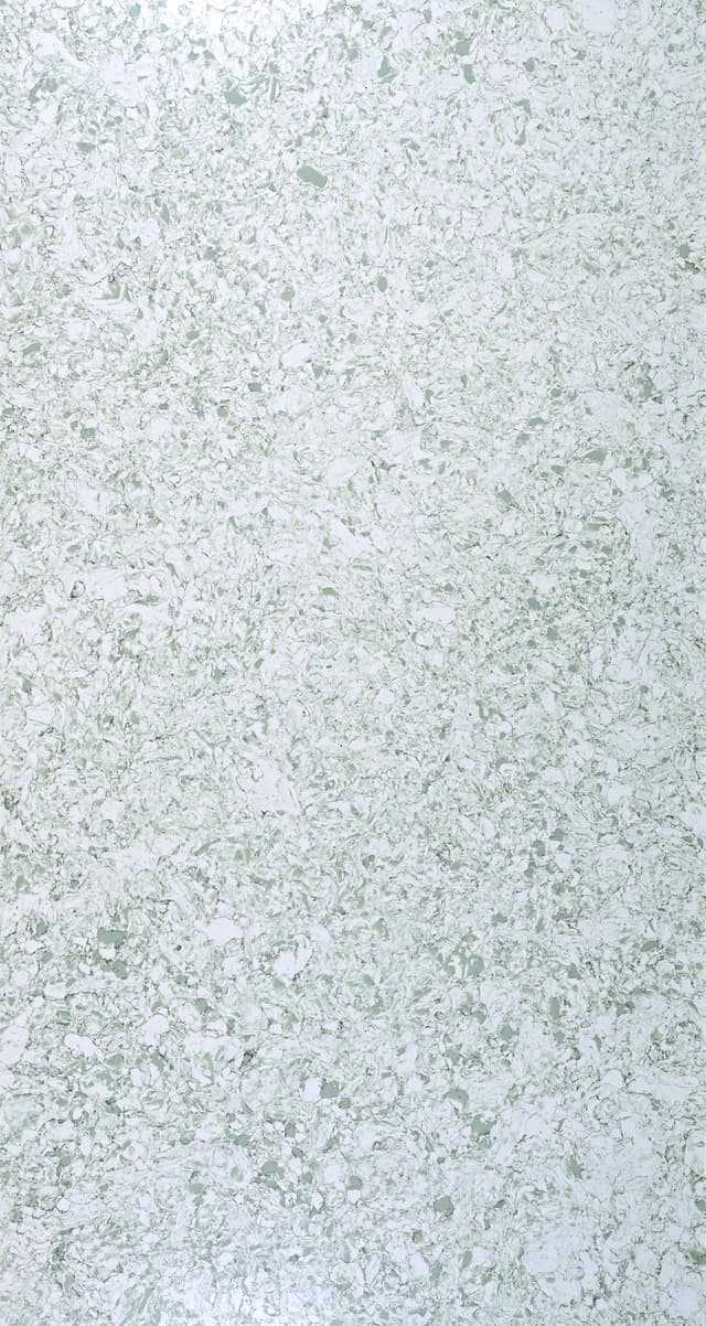 A white slab with a green glaze, translucent with ranges in colors from pale to grayish-green in a refined pattern.